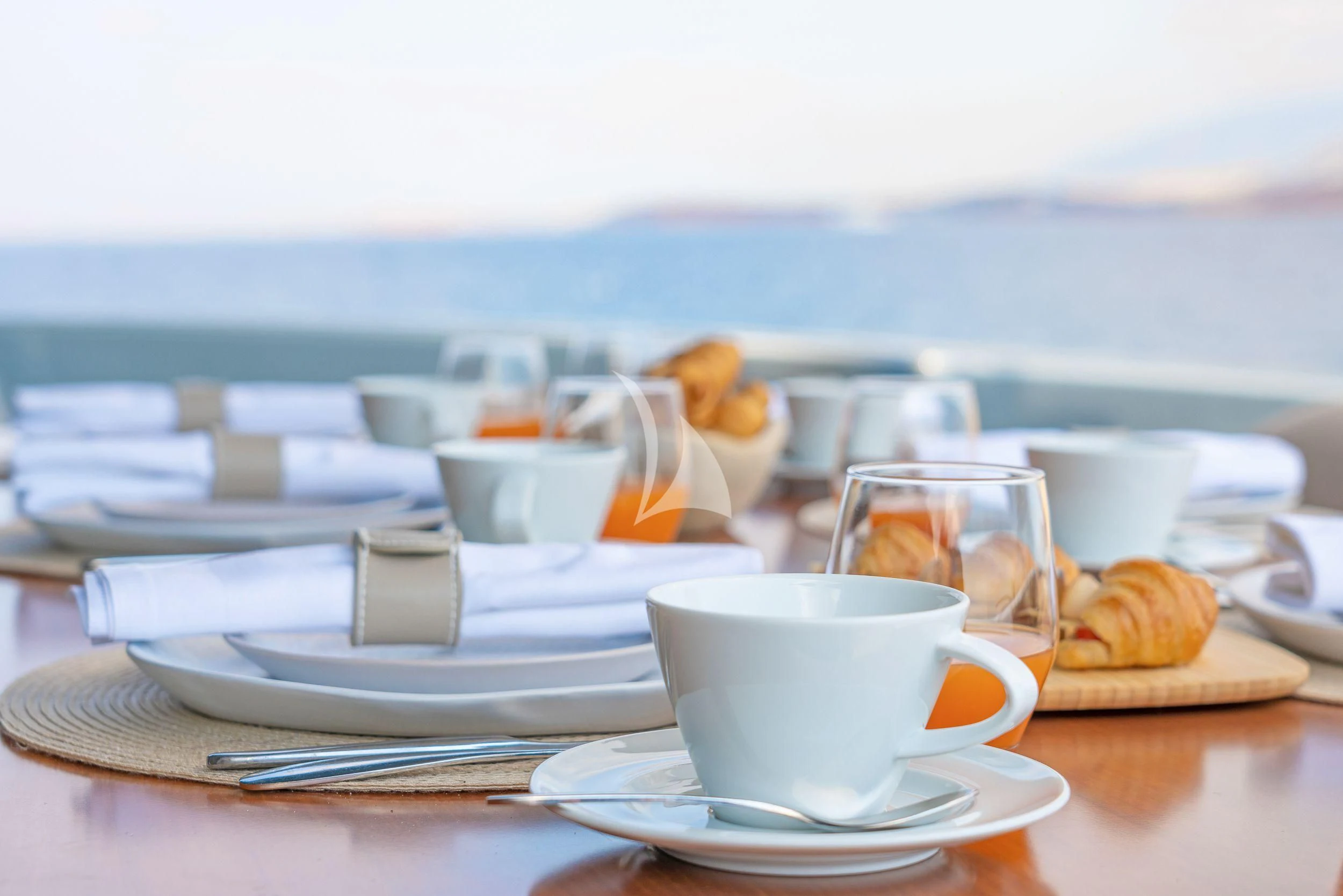 a table with plates and cups on it aboard WHATEVER Yacht for Charter