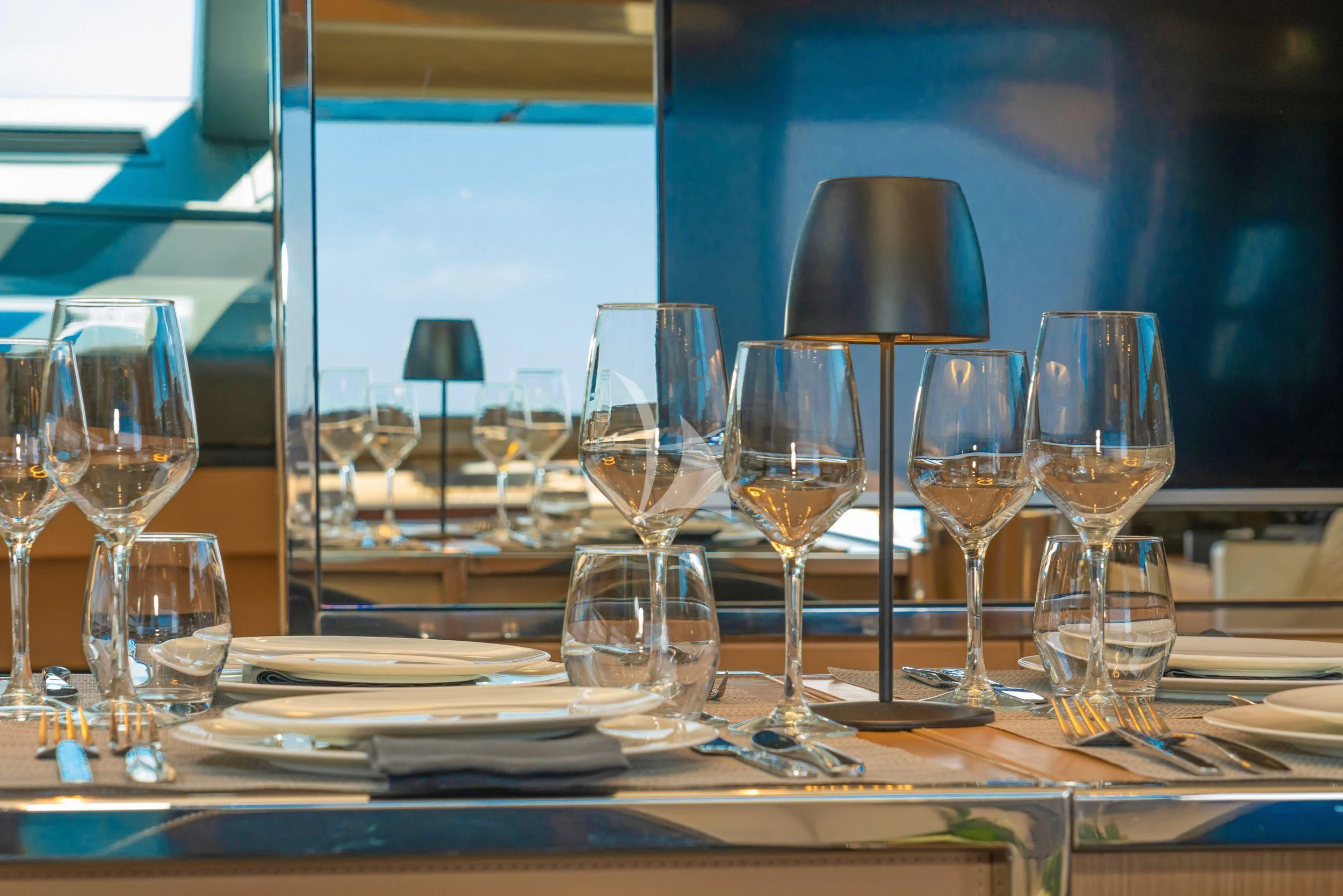 a table with wine glasses and plates aboard WHATEVER Yacht for Charter