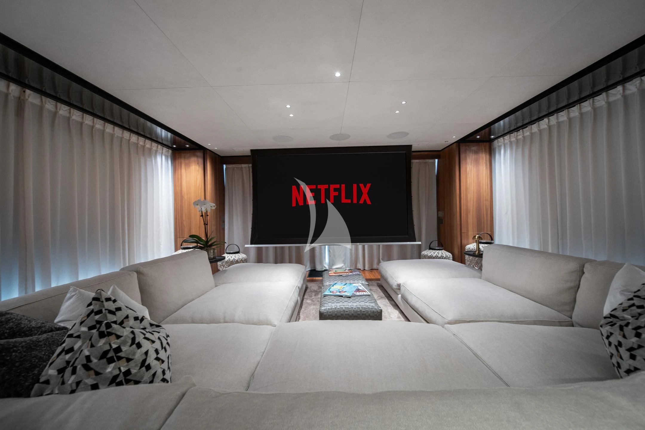 a living room with a large screen aboard AIX Yacht for Sale