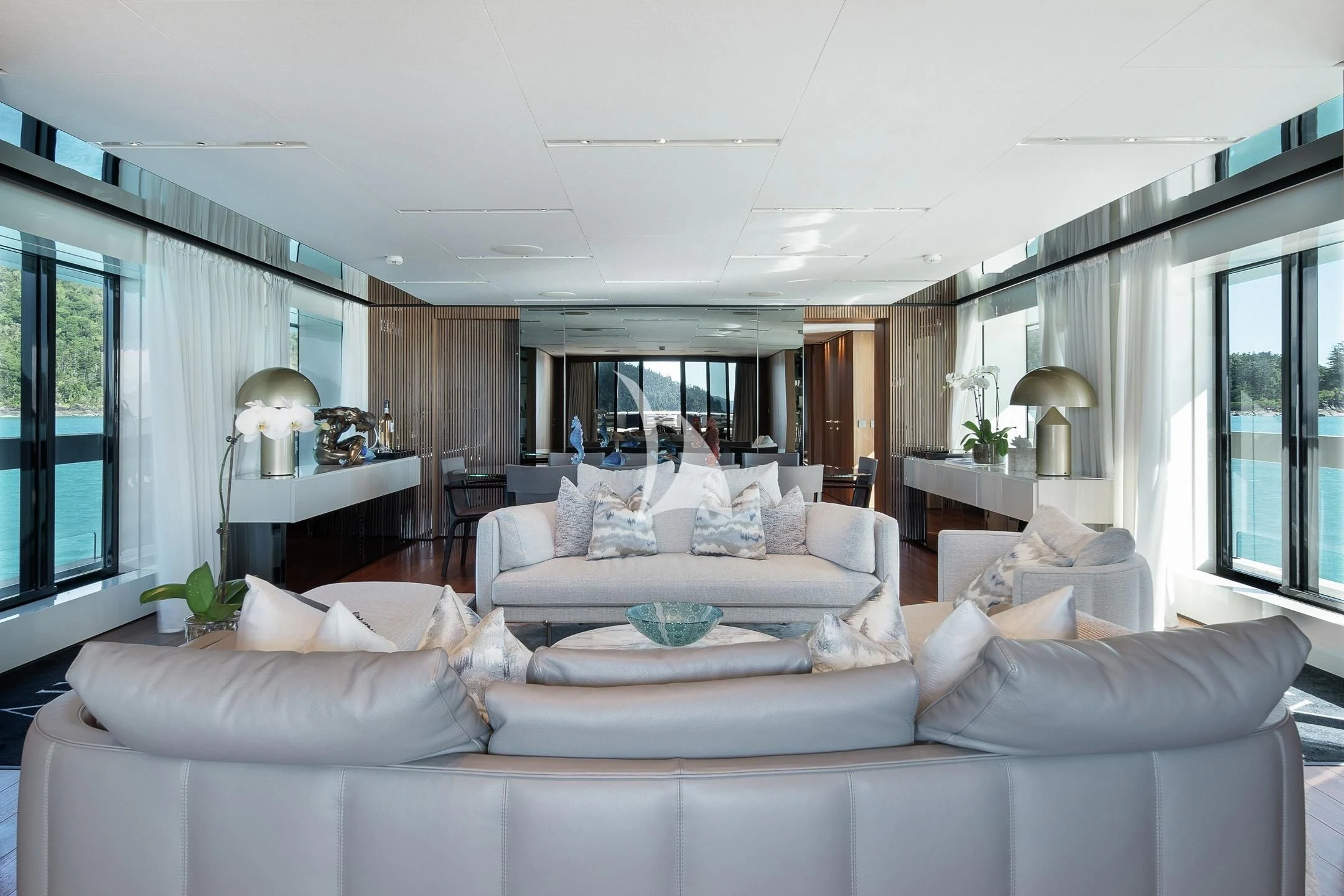 a living room with a large white couch and a large window aboard AIX Yacht for Sale