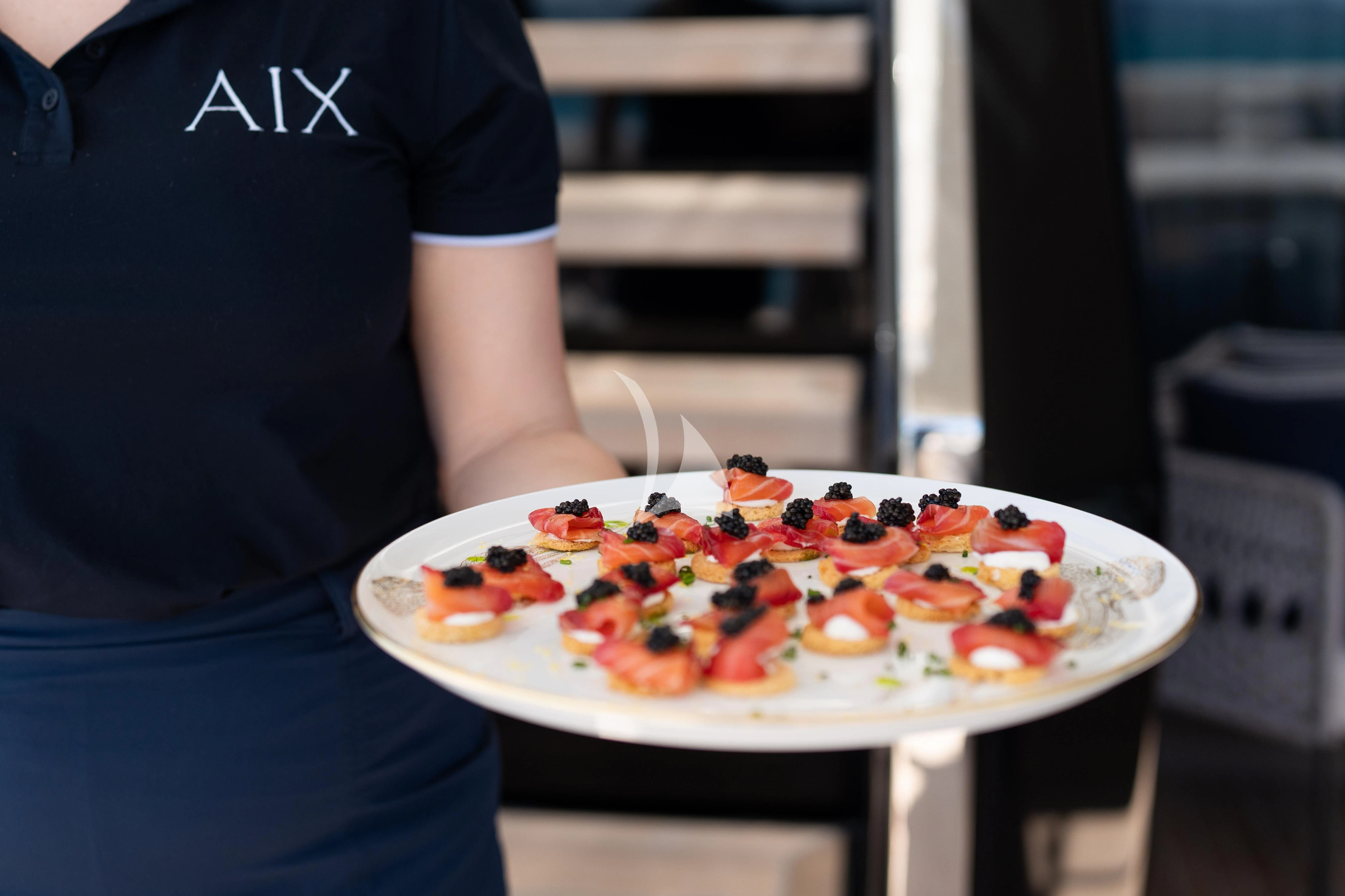 a person holding a pizza aboard AIX Yacht for Sale