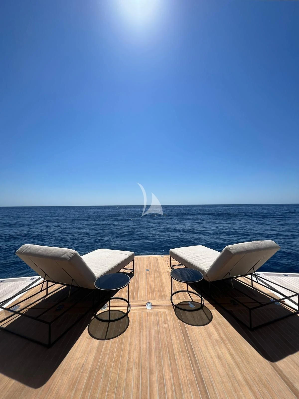 a deck with chairs and tables on it by the water aboard AIX Yacht for Sale