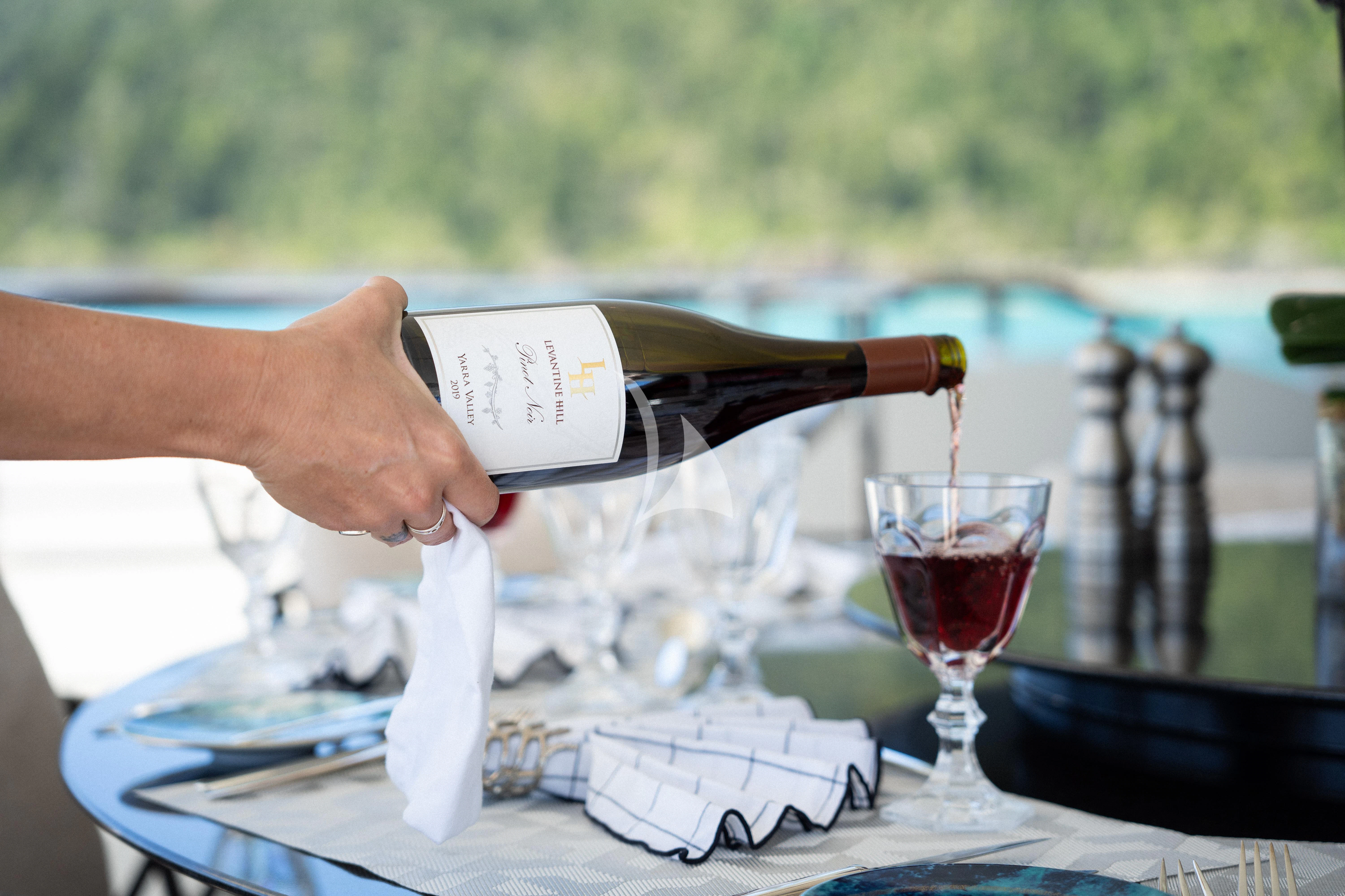 a person holding a bottle of wine aboard AIX Yacht for Sale