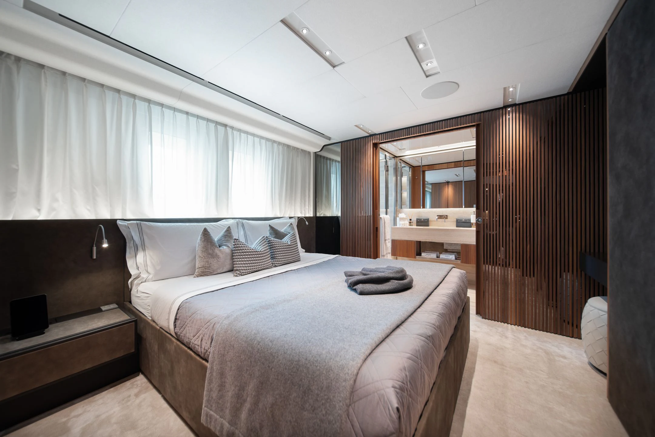 a bedroom with a bed and a wood door aboard AIX Yacht for Sale