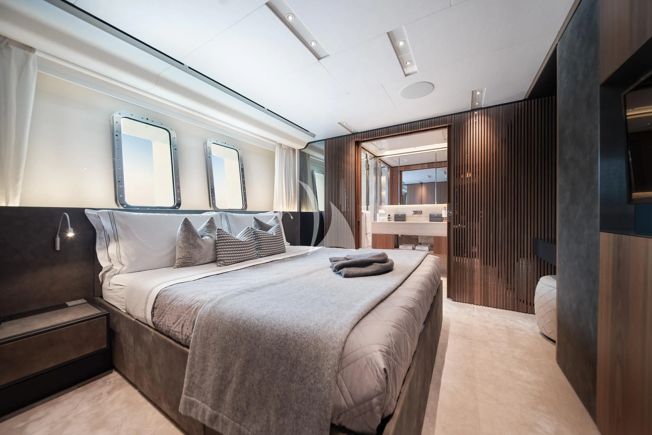 a bedroom with a bed and a wood door aboard AIX Yacht for Sale