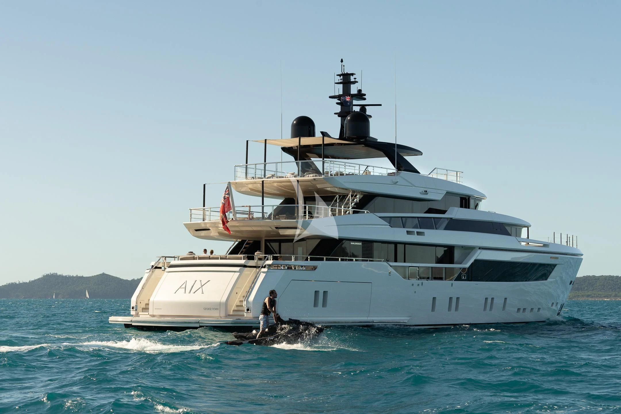 a large white boat with a person standing on it aboard AIX Yacht for Sale
