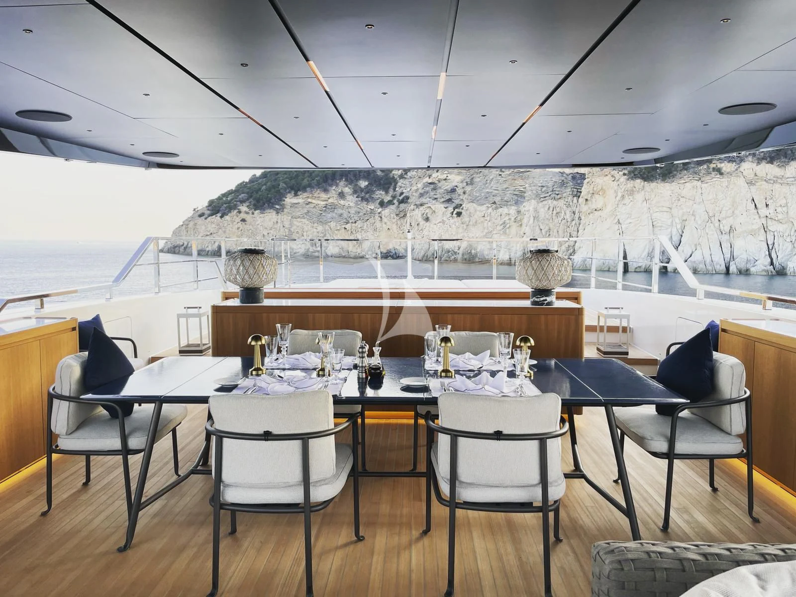 a table with chairs and a view of a snowy mountain aboard AIX Yacht for Sale