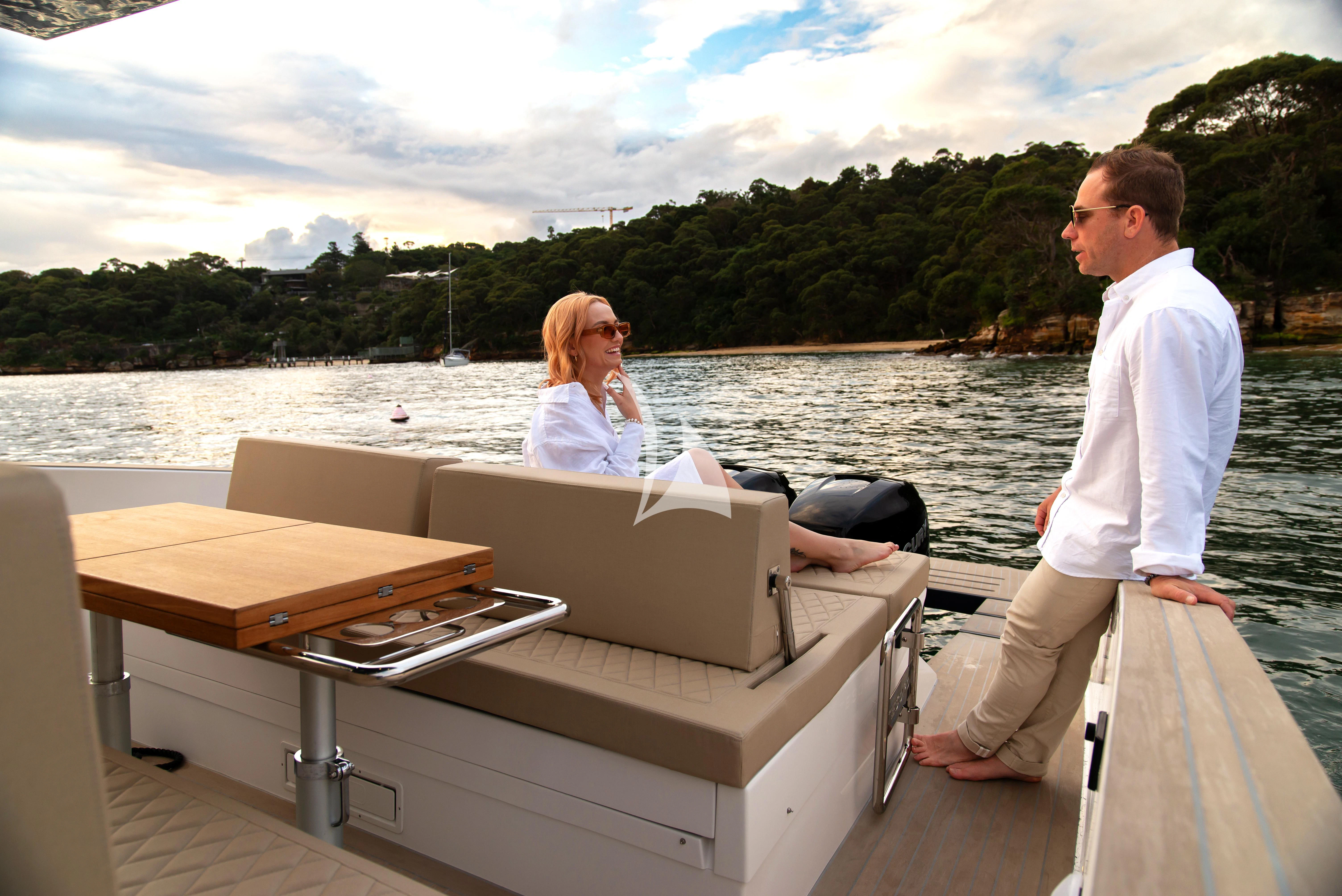 a man and woman sitting on a boat in the water aboard AIX Yacht for Sale