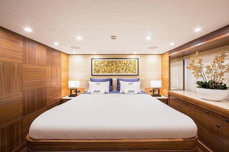 a bed with a white pillow aboard JOY Yacht for Sale