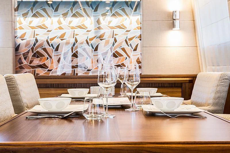 a table with plates and glasses on it aboard JOY Yacht for Sale
