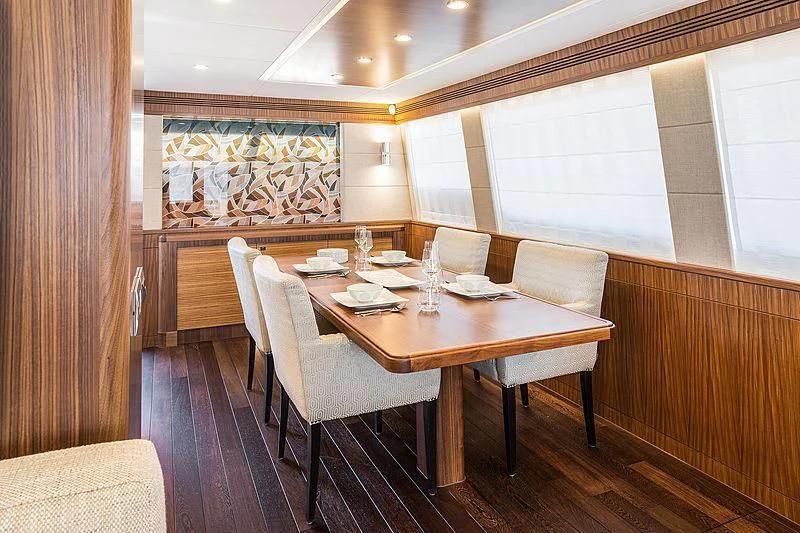 a table and chairs in a room aboard JOY Yacht for Sale