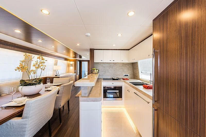 a kitchen with a dining table and chairs aboard JOY Yacht for Sale