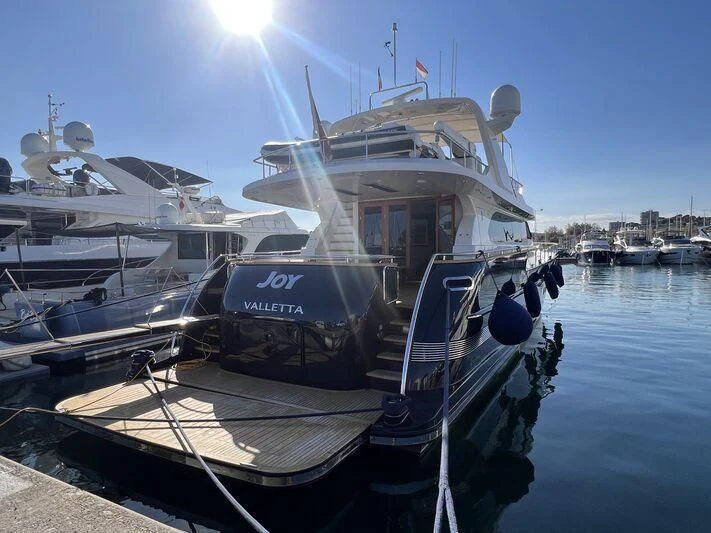 a boat docked at a pier aboard JOY Yacht for Sale
