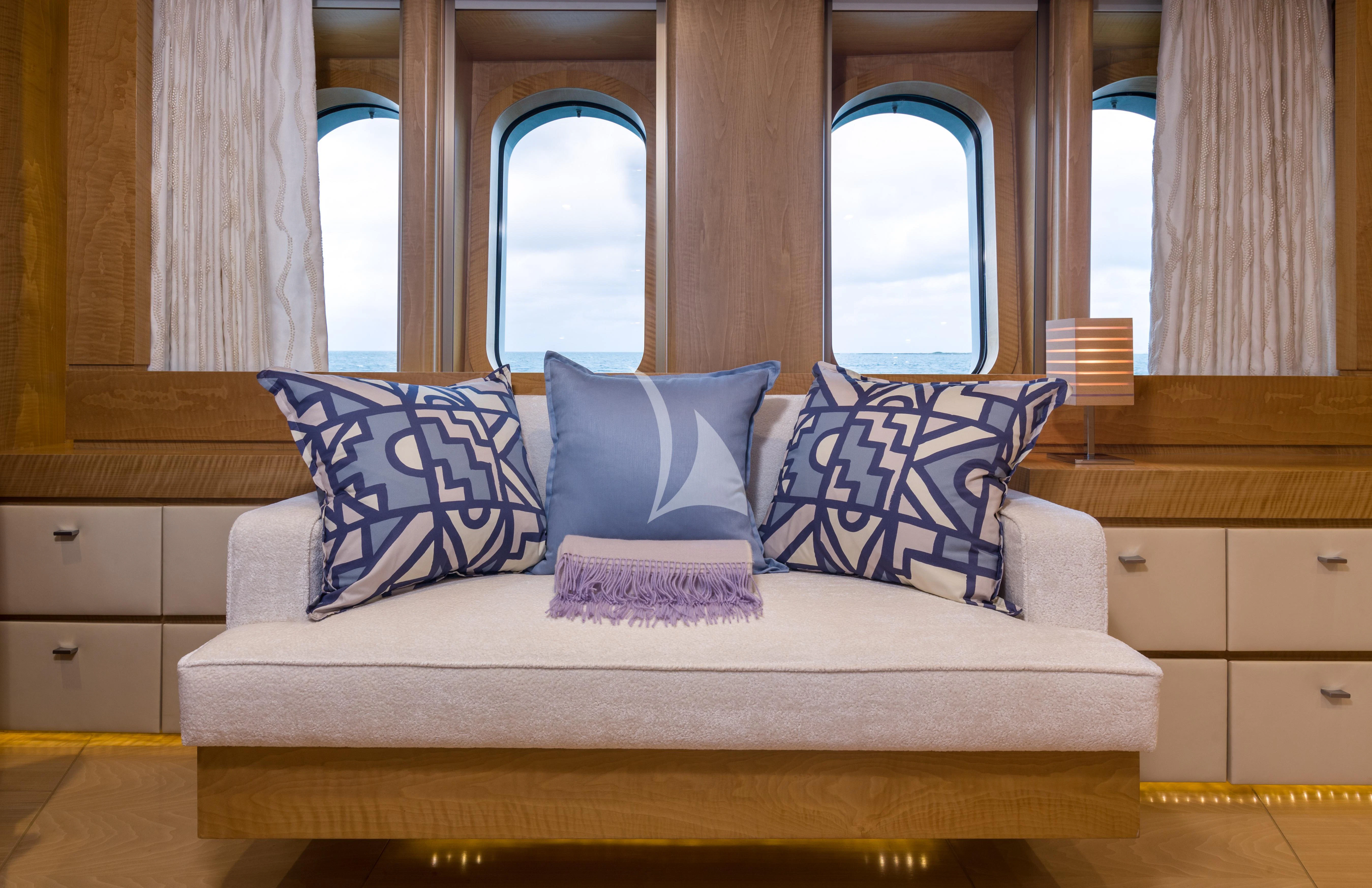 a couch with pillows aboard BACA Yacht for Charter