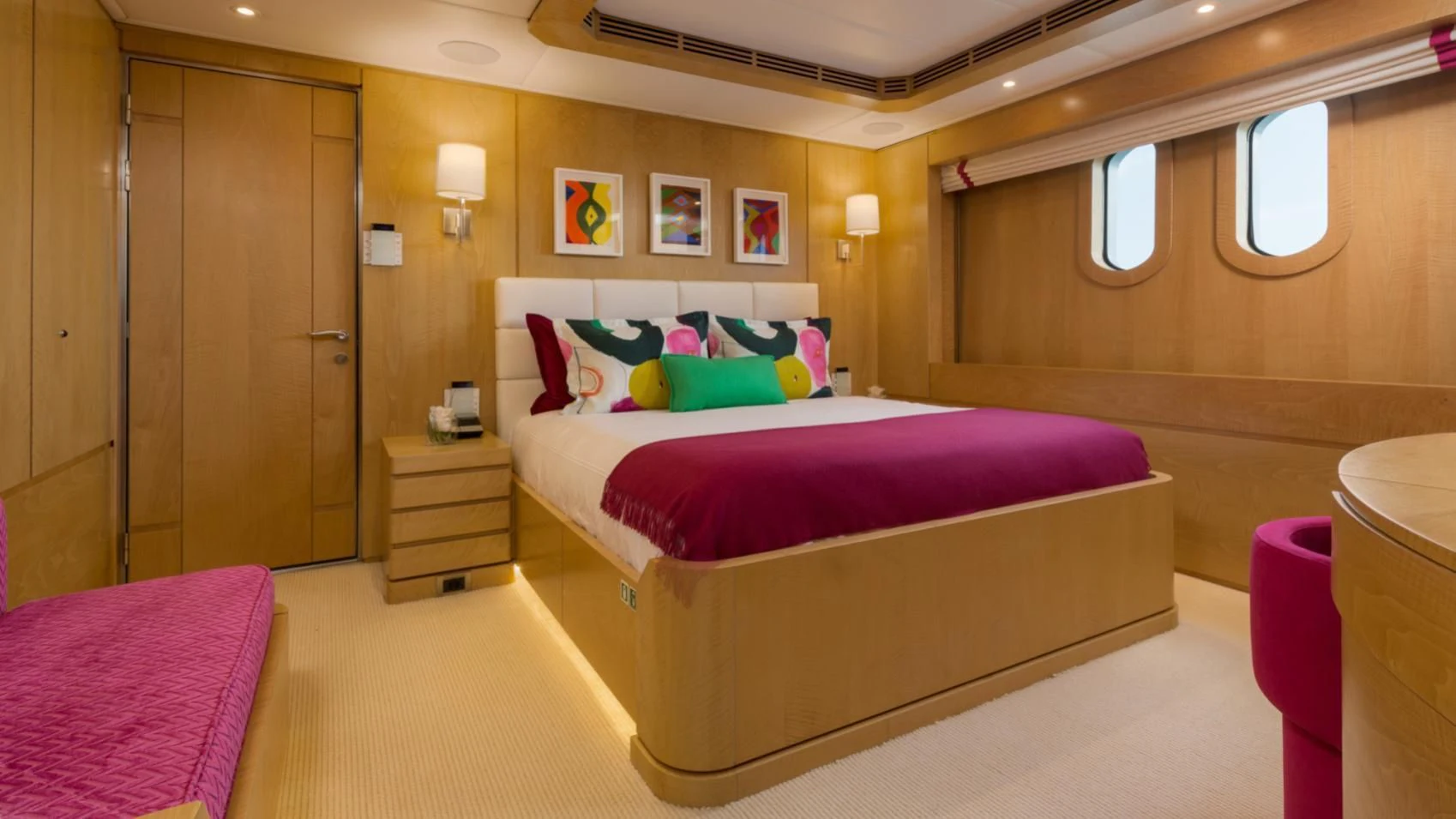 a room with a bed and a dresser aboard BACA Yacht for Charter