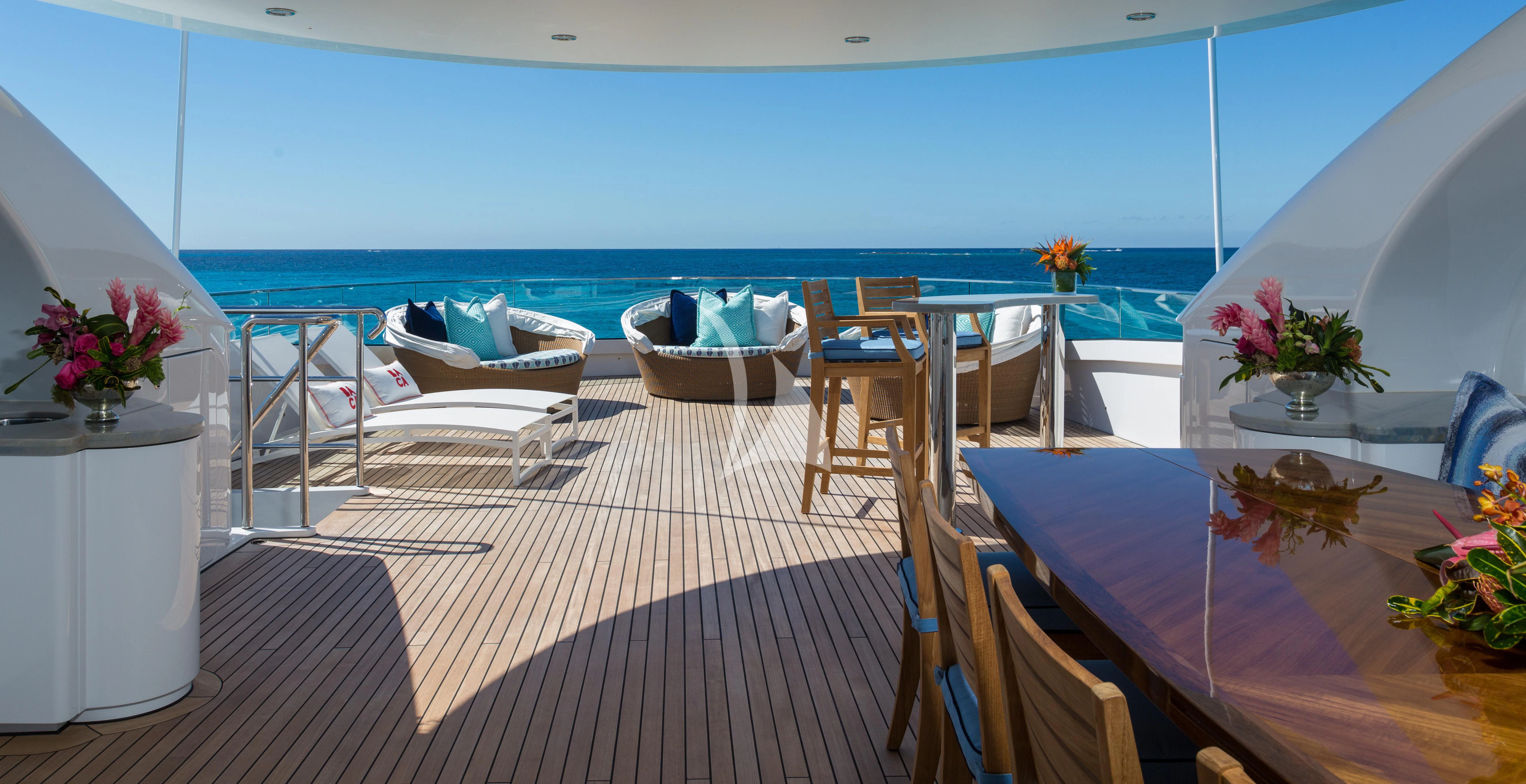 a room with a table chairs and flowers on the floor aboard BACA Yacht for Charter