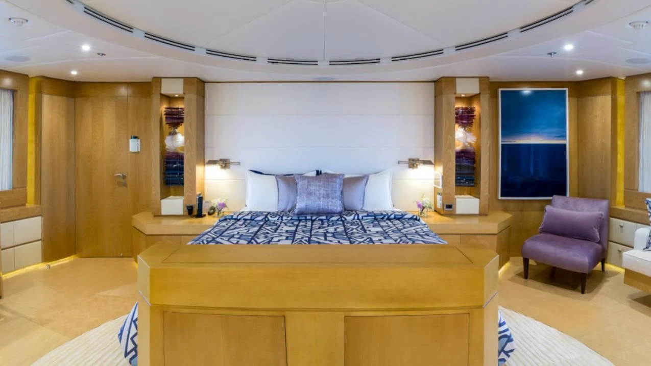 a large room with a bed and a chair aboard BACA Yacht for Charter