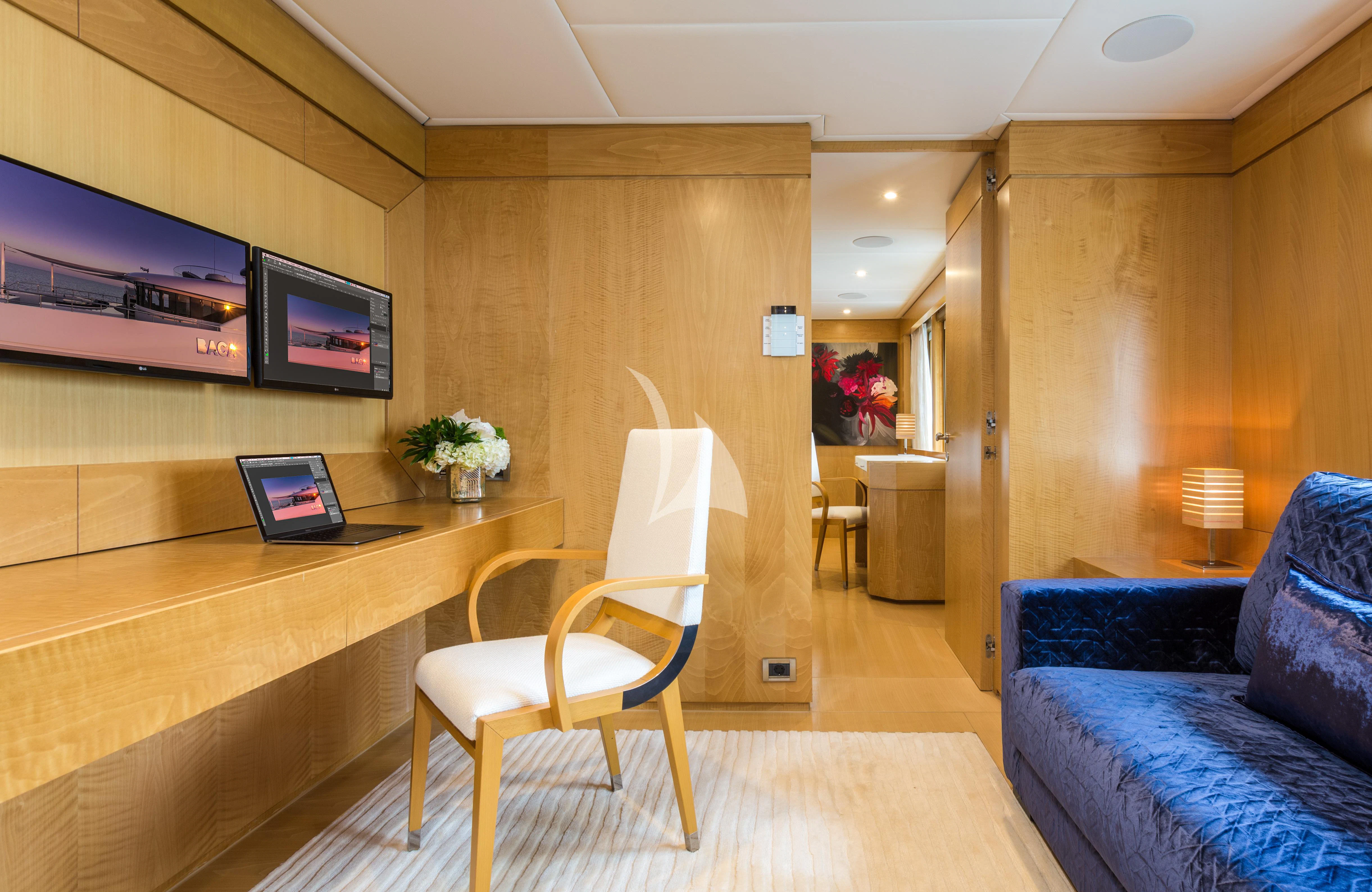 a room with a desk and chairs aboard BACA Yacht for Charter