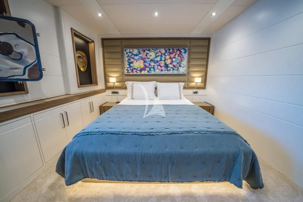 a bed with a blue sheet aboard DEEP WATER Yacht for Charter