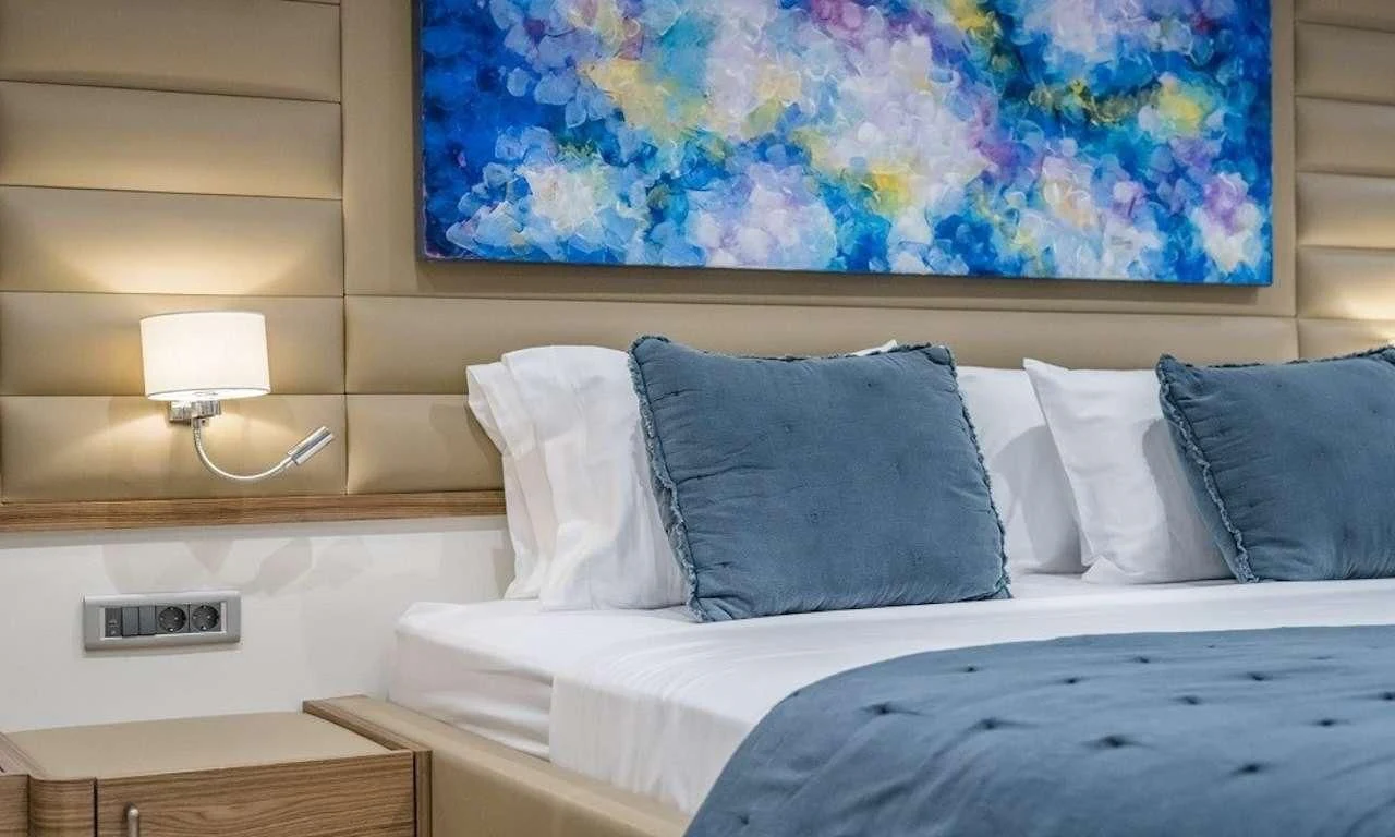 a bed with a blue and white bed spread aboard DEEP WATER Yacht for Charter