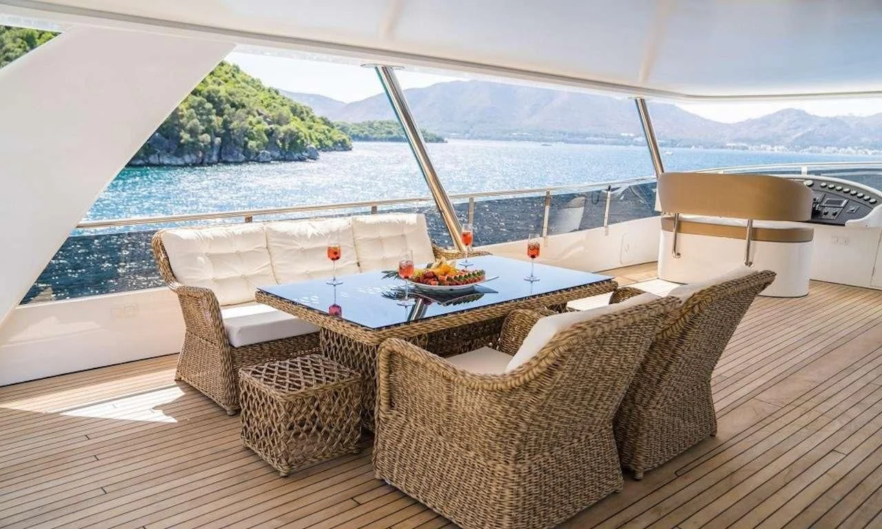 a table and chairs on a deck overlooking a large body of water aboard DEEP WATER Yacht for Charter