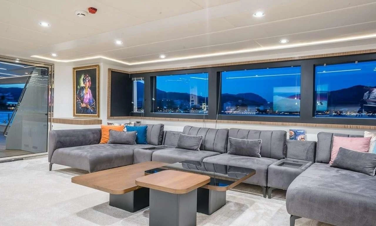 a living room with a large sofa and a large screen aboard DEEP WATER Yacht for Charter