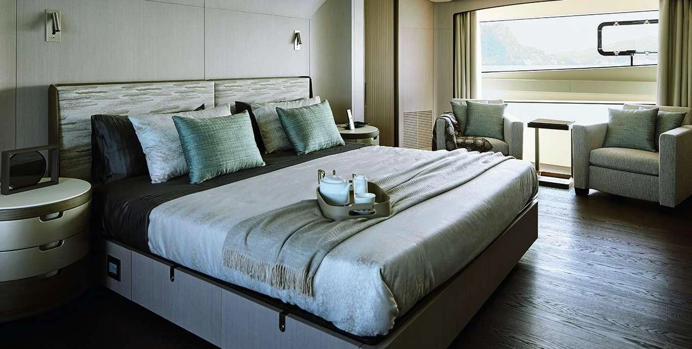 a bed with a white sheet and pillows aboard CASA Yacht for Sale