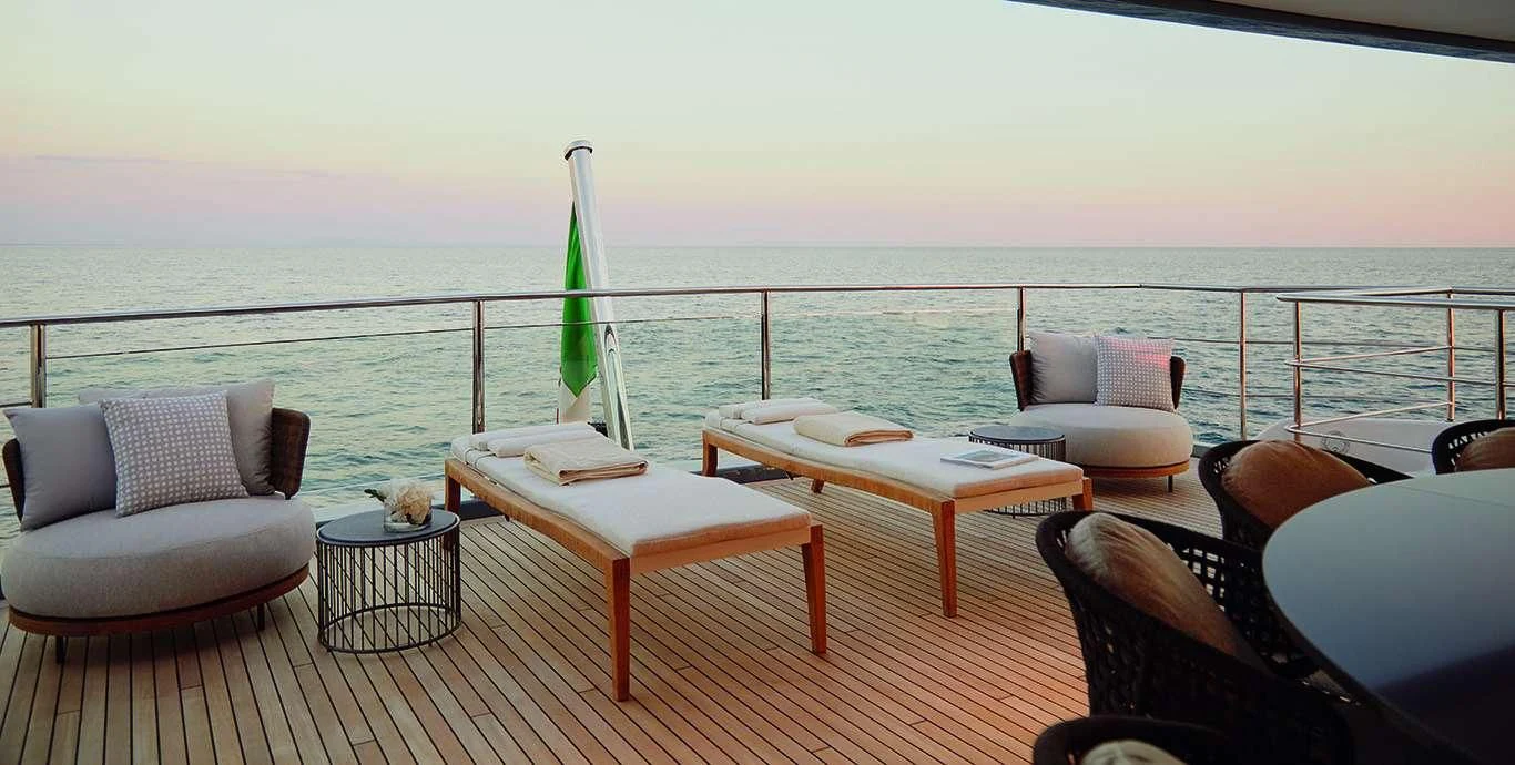 a deck with a table and chairs on it aboard CASA Yacht for Sale