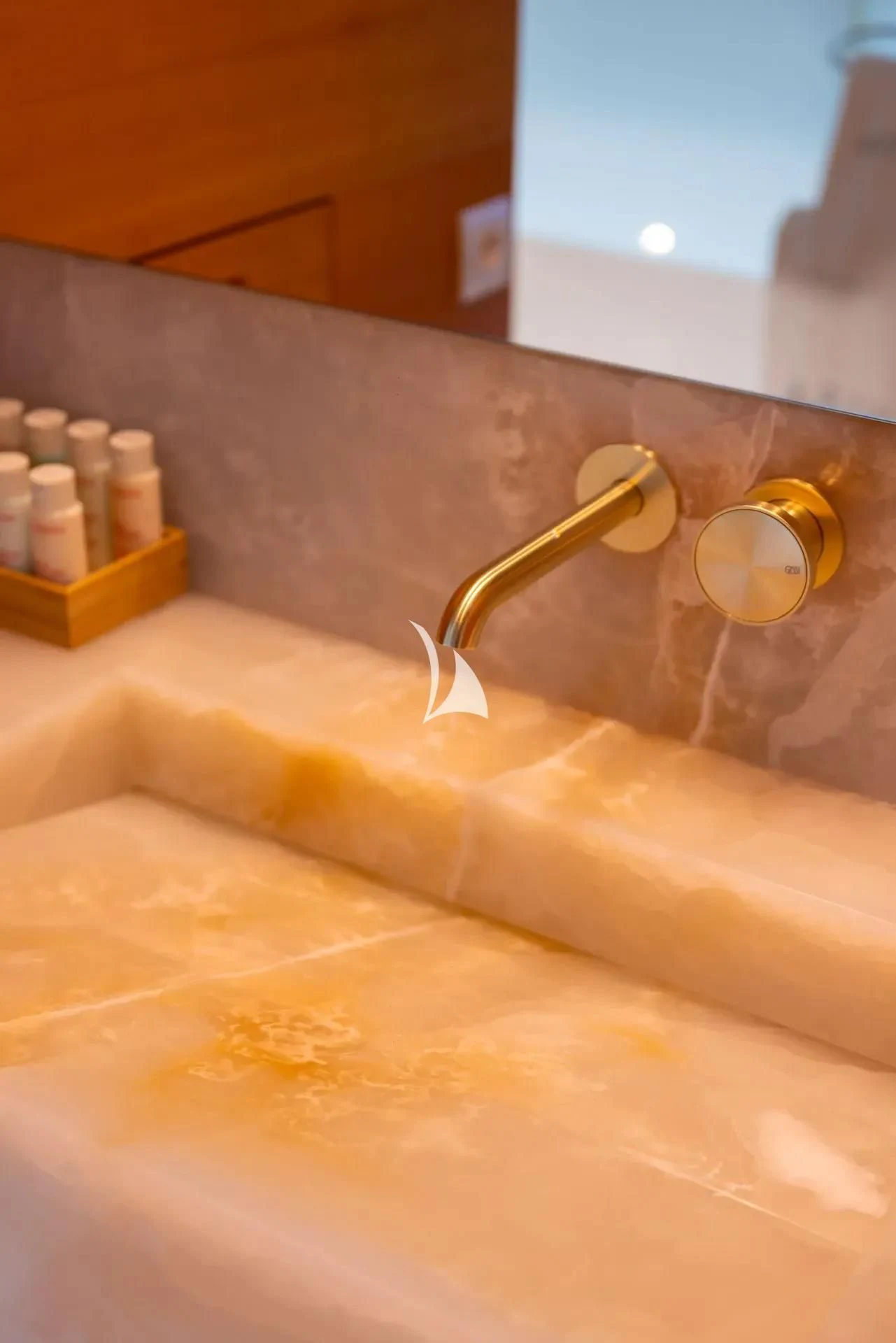 a bathroom sink with soap dispenser and a mirror aboard LUISA Yacht for Charter