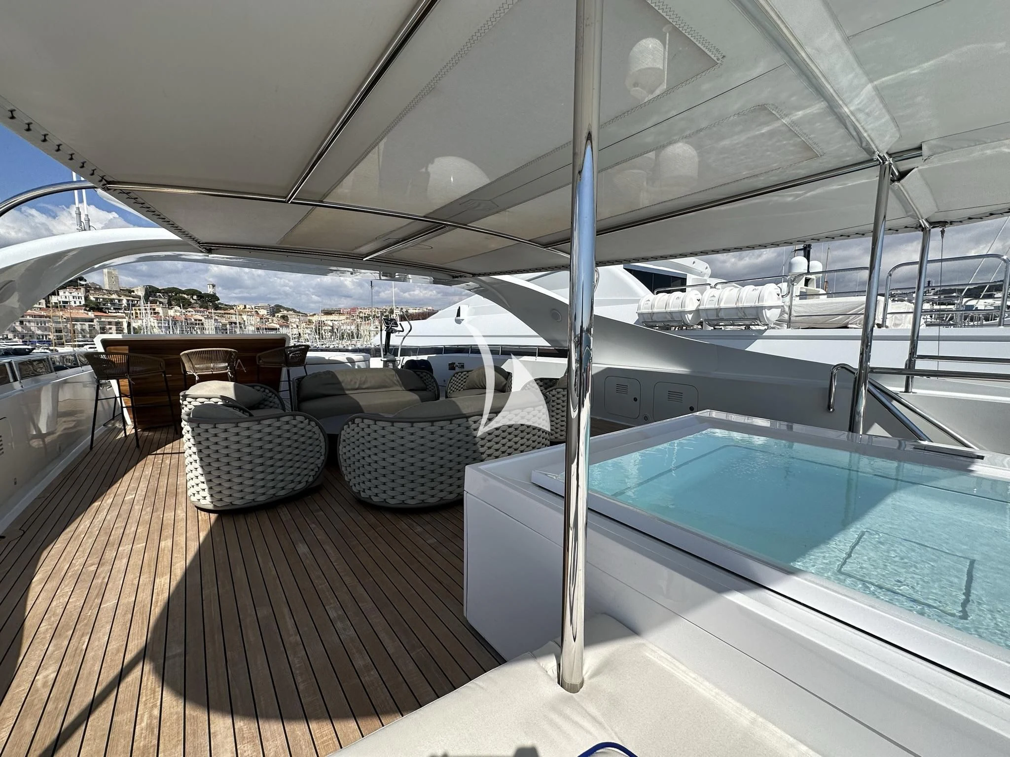 a deck with a pool and a deck with chairs and a large building aboard LUISA Yacht for Charter