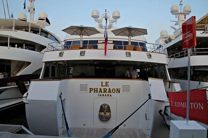 a white boat with a flag on it aboard LE PHARAON Yacht for Sale