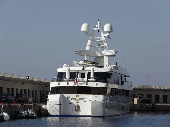 a large white boat in a harbor aboard LE PHARAON Yacht for Sale