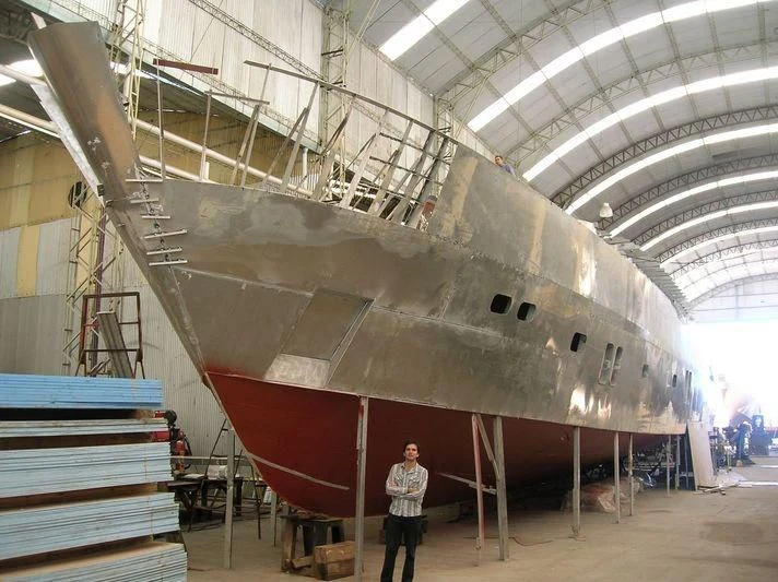 a person standing next to a large ship in a building aboard ANDES Yacht for Sale