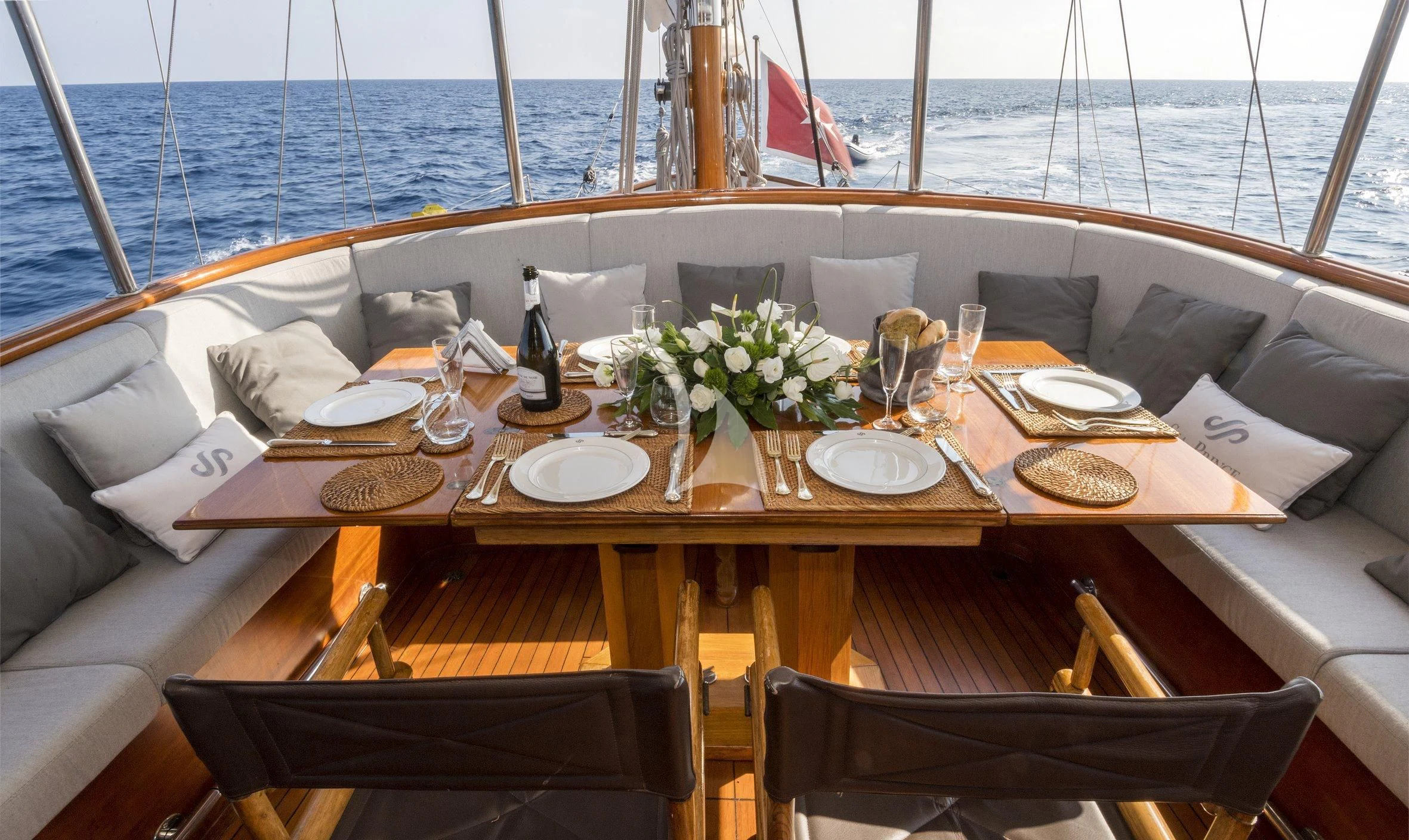 a table with plates and flowers on it aboard SEA PRINCE Yacht for Sale