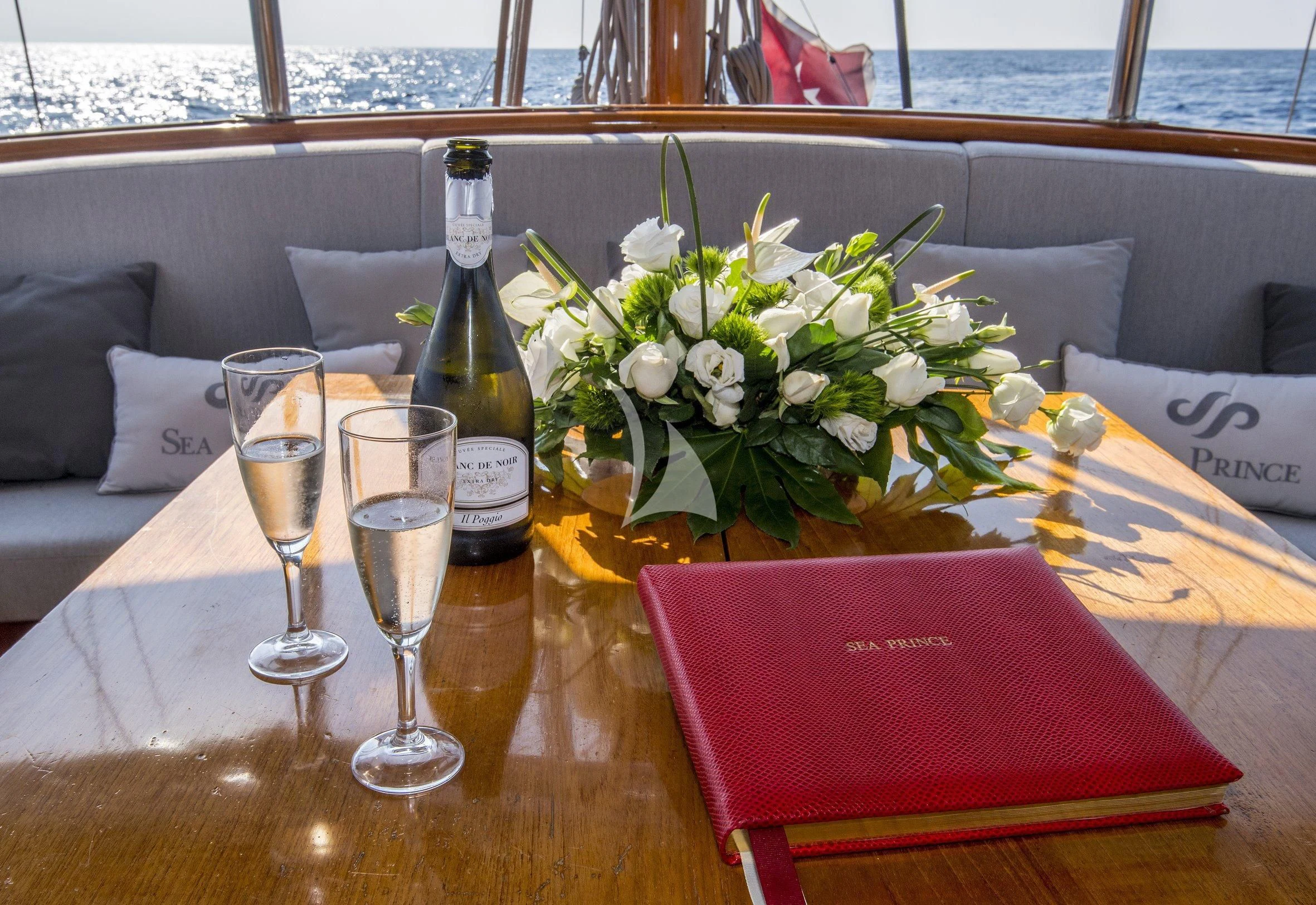 a table with wine glasses and flowers aboard SEA PRINCE Yacht for Sale