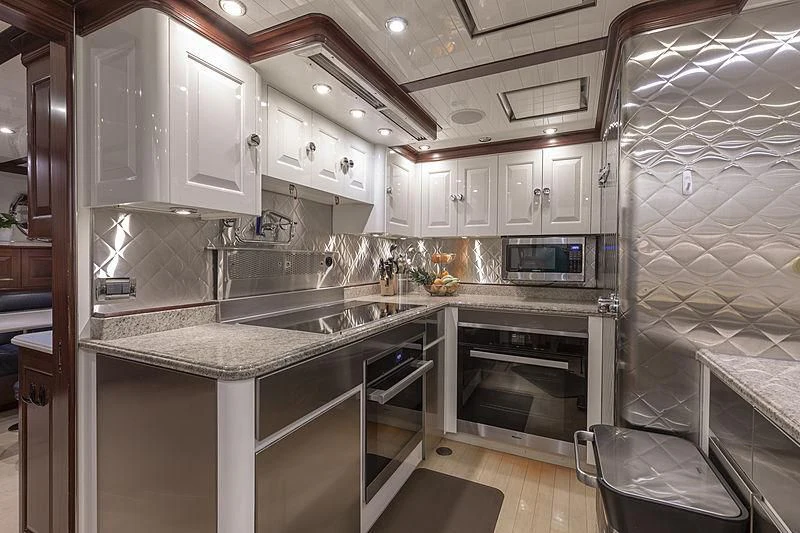 a kitchen with white cabinets aboard NADAN Yacht for Sale