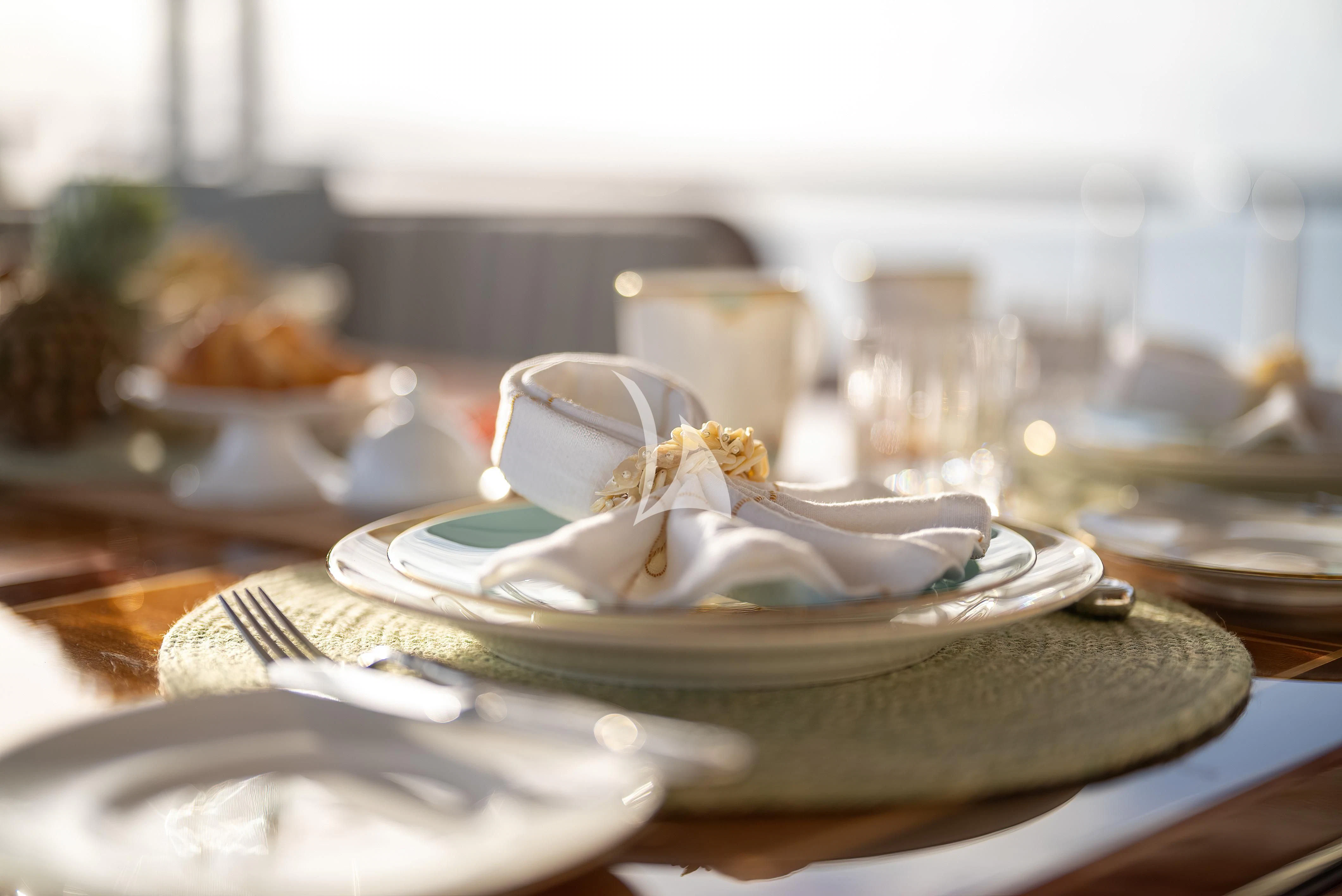 a plate with a gold ring on it and a silver plate with a gold leaf on it aboard NADAN Yacht for Sale