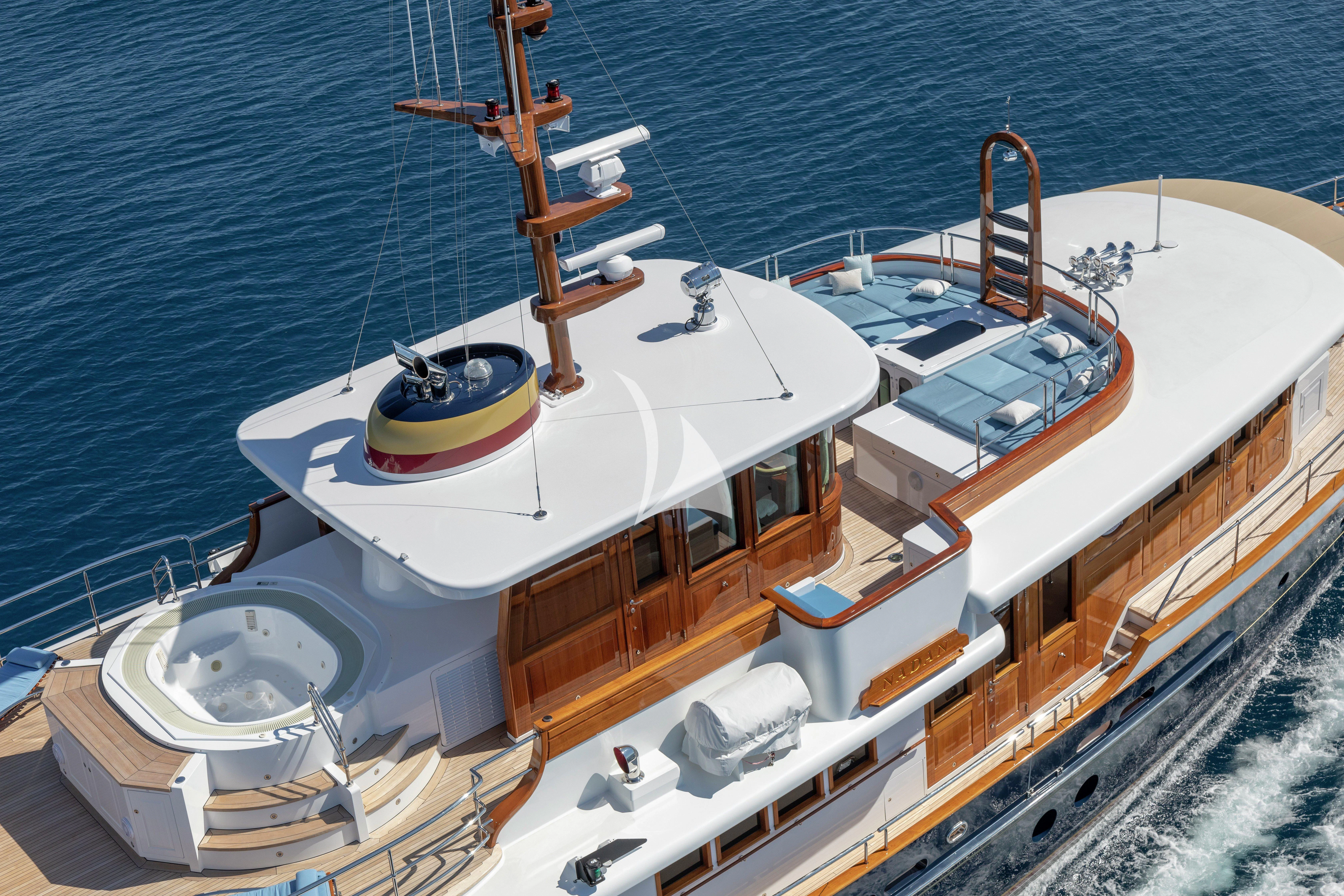 a large white ship with a large orange crane on the deck aboard NADAN Yacht for Sale