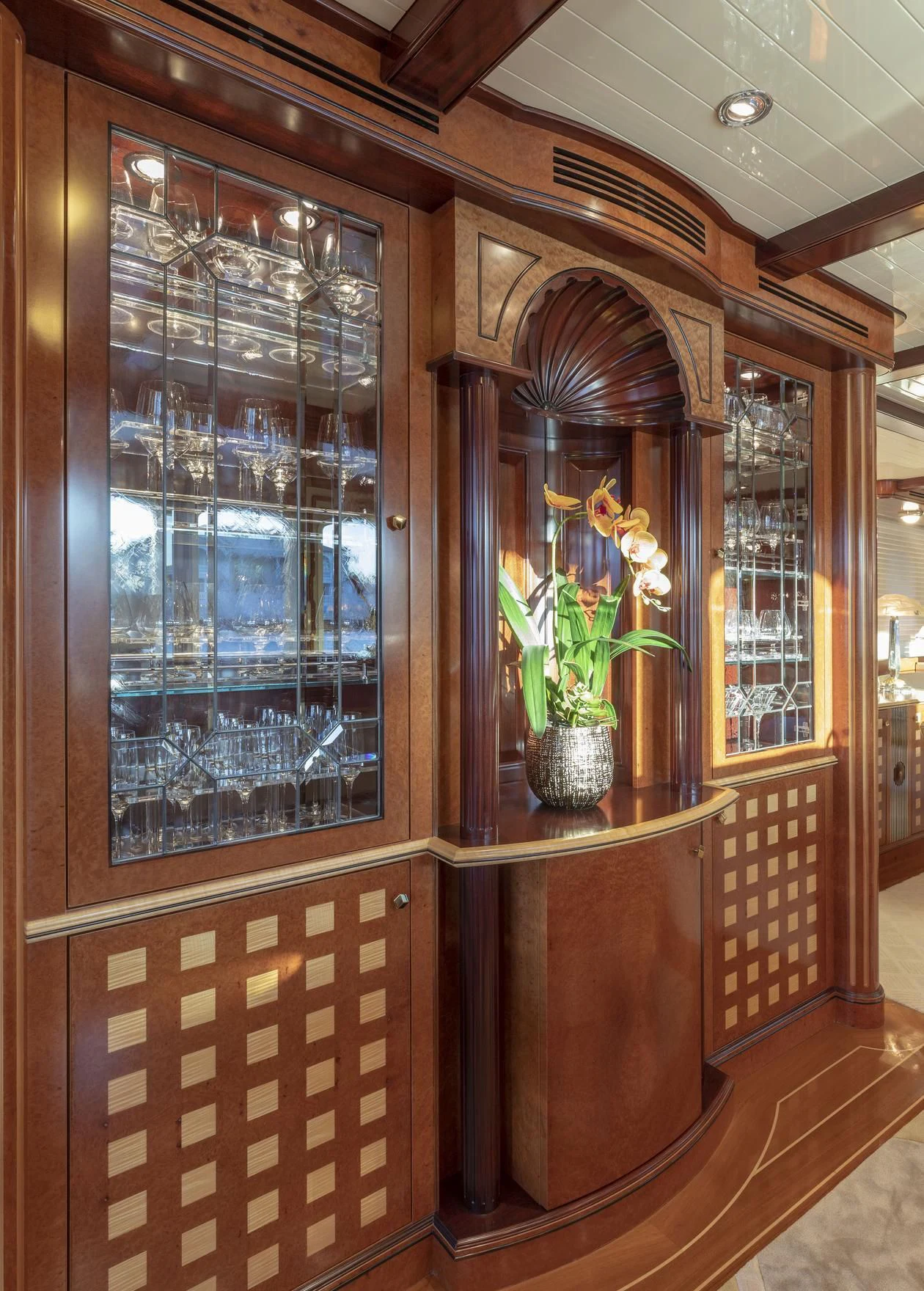 a room with a wood cabinet and a vase with flowers in it aboard NADAN Yacht for Sale