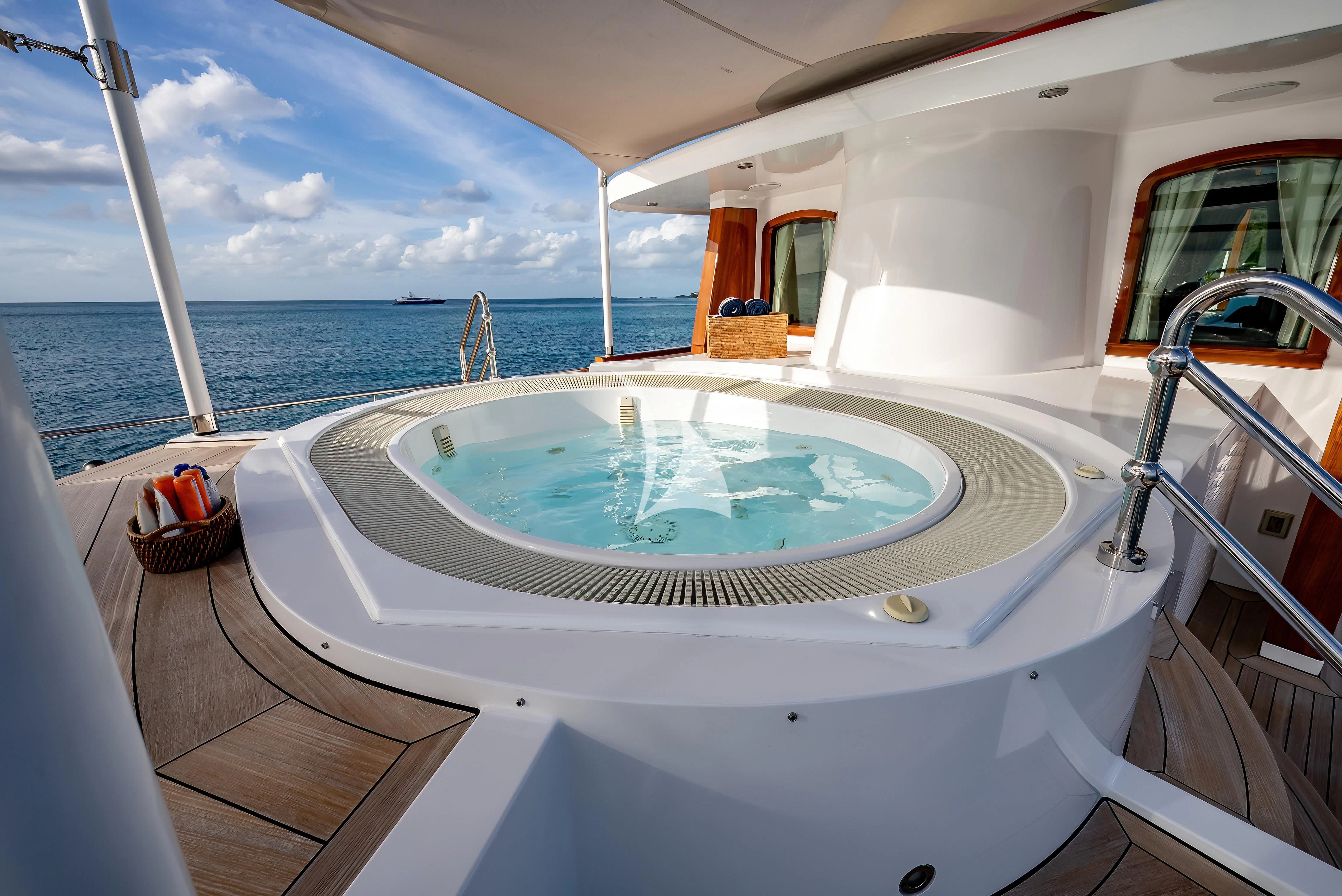 a large jacuzzi on a balcony overlooking the ocean aboard NADAN Yacht for Sale