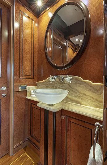 a bathroom with a round mirror aboard NADAN Yacht for Sale