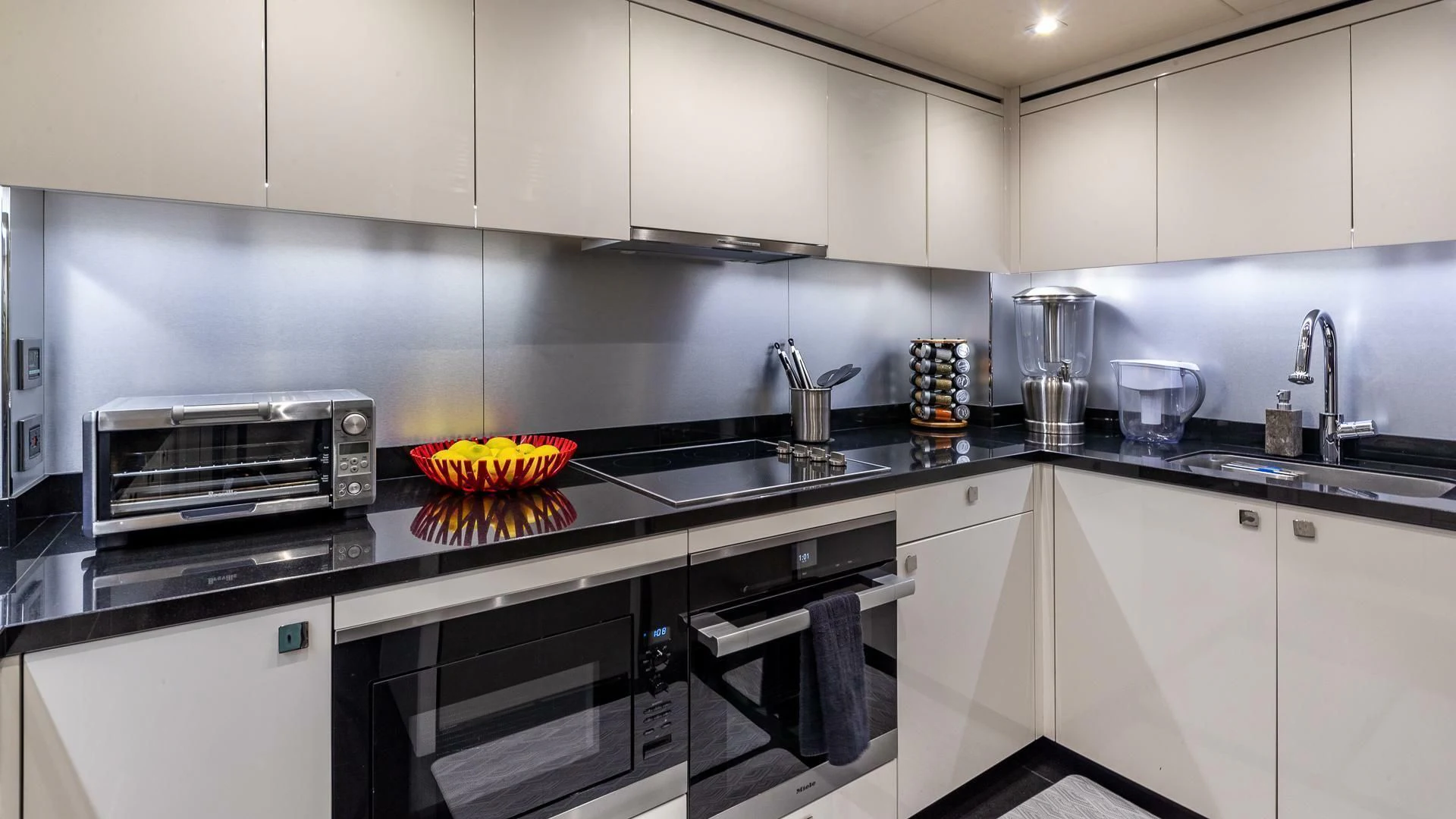 a kitchen with white cabinets aboard MIRRACLE Yacht for Sale