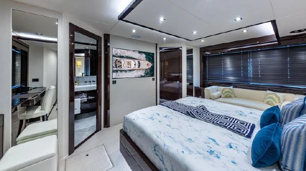 a bedroom with a bed and a desk aboard MIRRACLE Yacht for Sale
