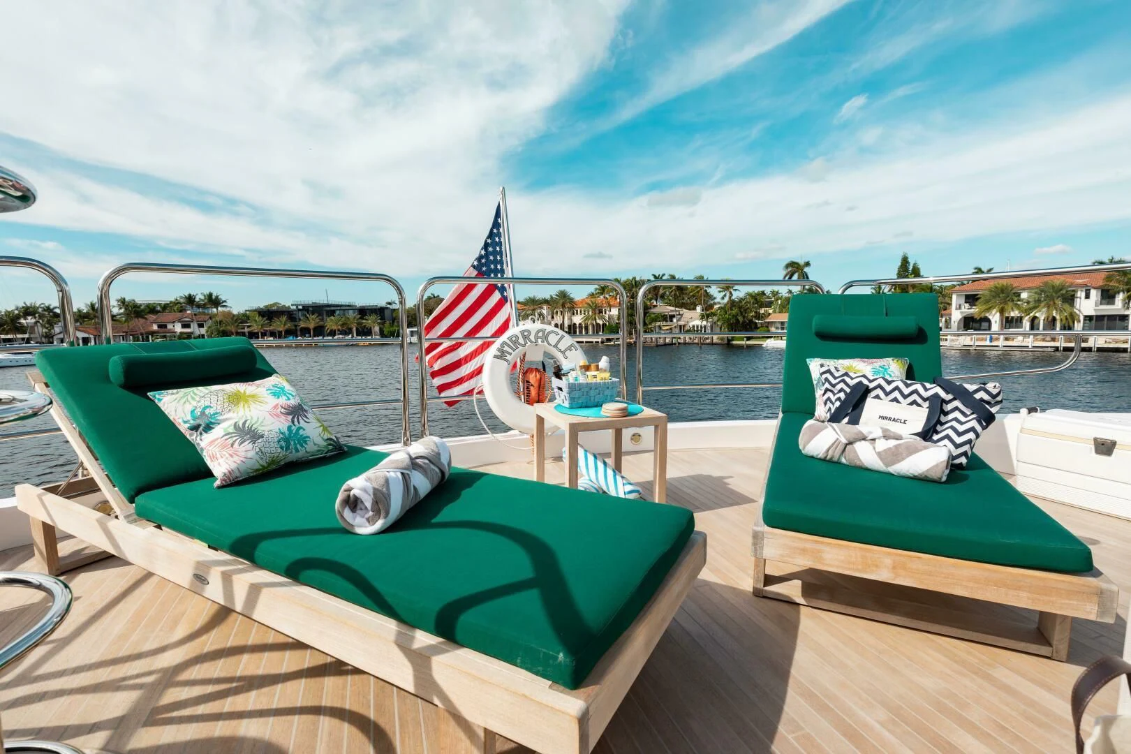 a deck with a flag and a table and chairs on it aboard MIRRACLE Yacht for Sale