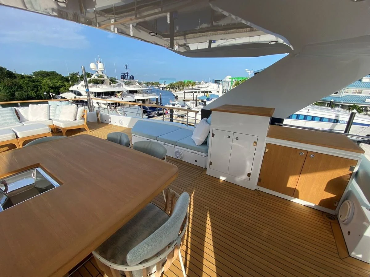 a deck with a table and chairs on it aboard PERSISTENCE Yacht for Sale