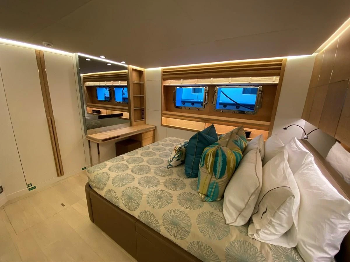 a bed with pillows and a television aboard PERSISTENCE Yacht for Sale
