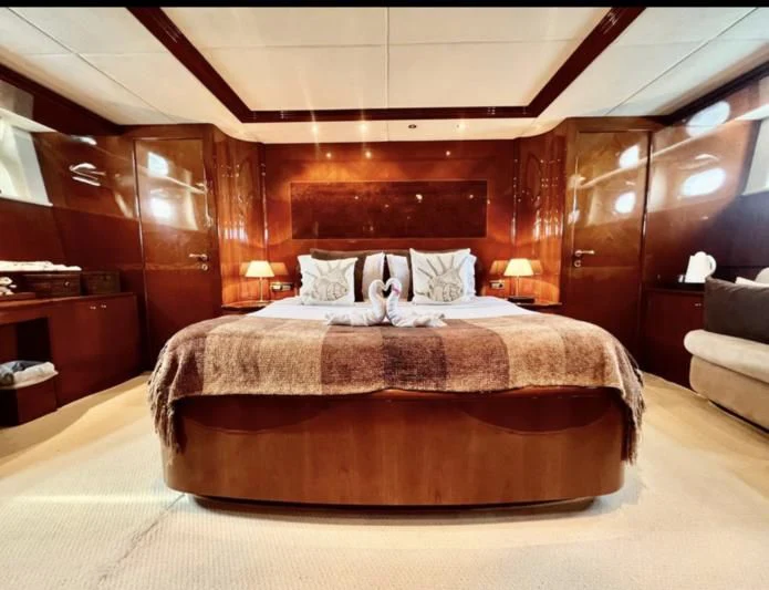 a bed with a brown bed spread aboard GARI Yacht for Sale