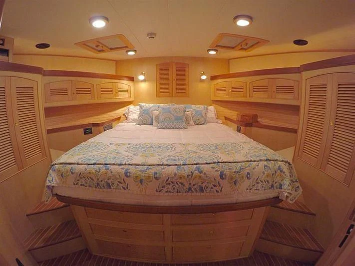 a room with a bed and a wood door aboard BELLA Yacht for Sale