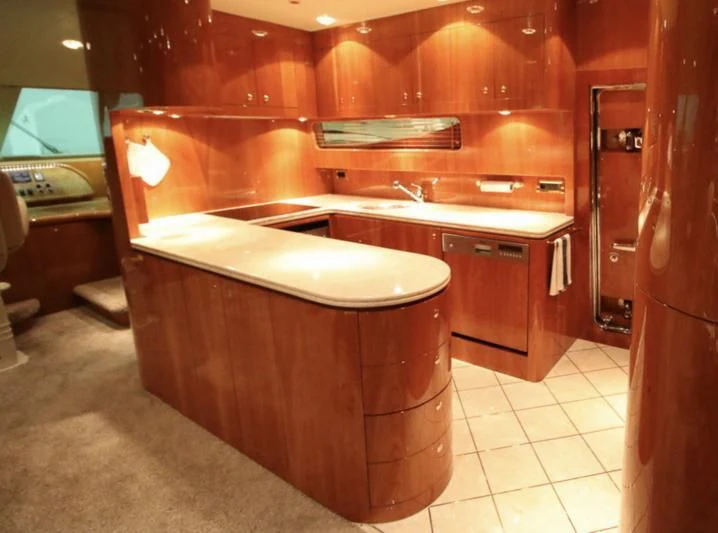 a large kitchen with wooden cabinets aboard JOYS Yacht for Sale