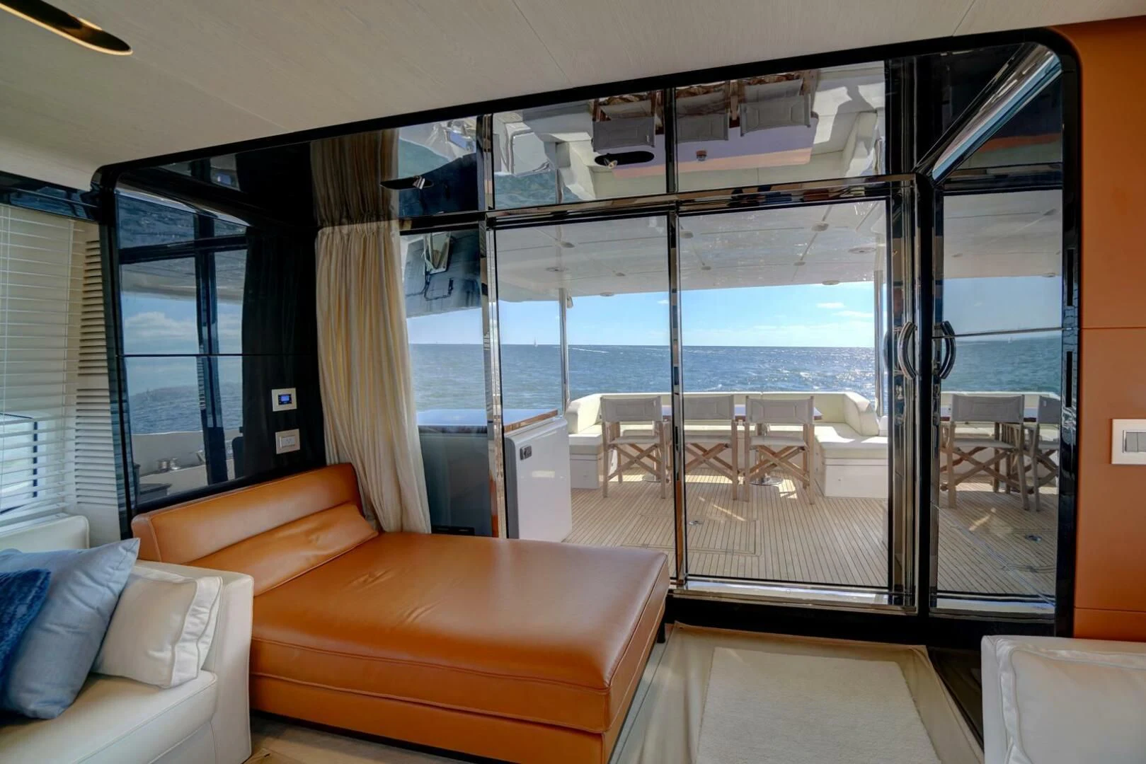 a room with a glass door and a couch and a table with chairs aboard 80 AZIMUT Yacht for Sale